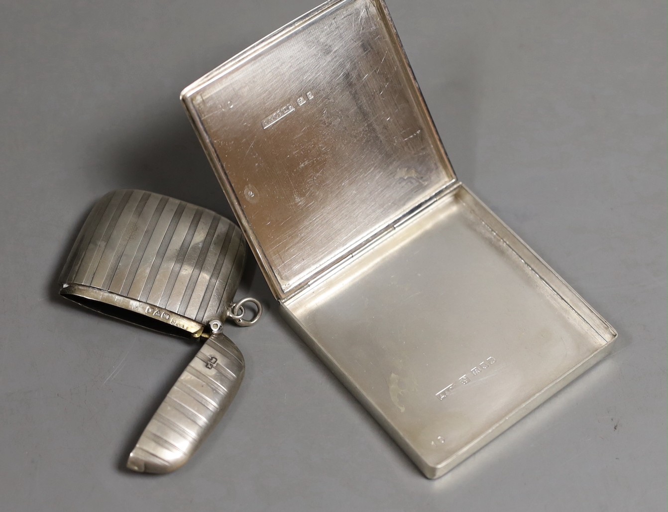 A George VI part engine turned silver cigarette case?, by Asprey & Co, London, 1945, 68mm, an earlier silver vesta case by Asprey & Co Ltd and a modern silver cased atomiser, retailed by Asprey.